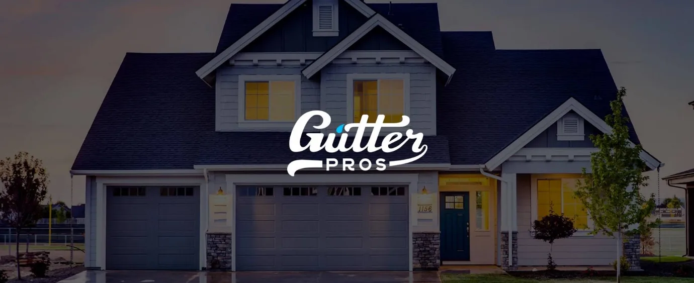 Gutter Pros logo over a home at dusk