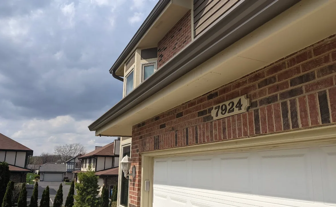 Home 36 Brick home with tan seamless gutter
