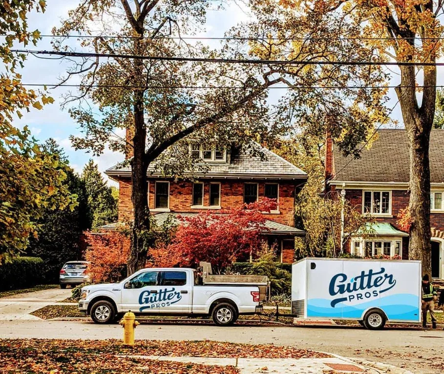 Gutter Pros pickup truck and branded trailer parked on a residential street